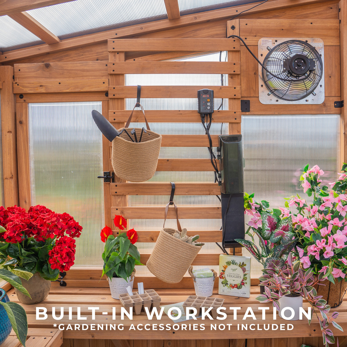 The Willow greenhouse's built-in cedar slat wall holds hanging baskets and tools above a workstation with staging shelves.